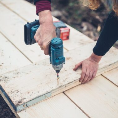 A young woman is using an impact driver