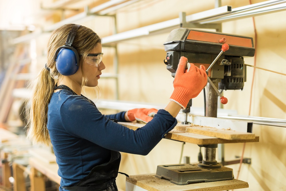 woman using a drill press